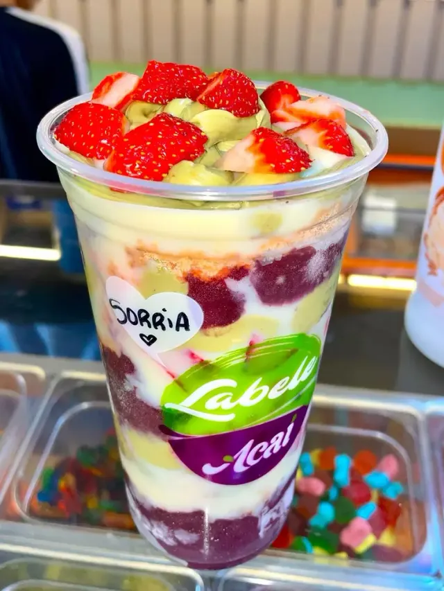 Copo de açaí da Labele com morangos por cima e um coração com a palavra Sorria escrito na tampa