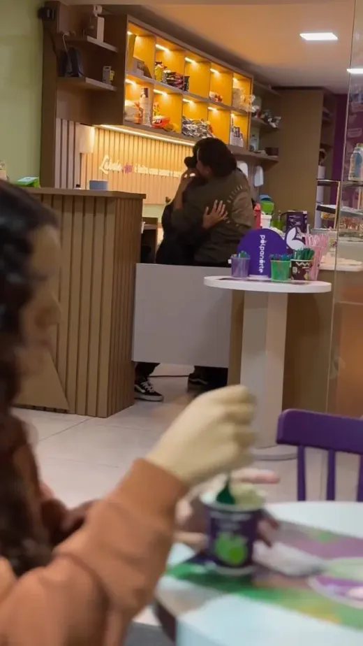 Interior da Labele com balcão, prateleiras e uma pessoa tomando açaí